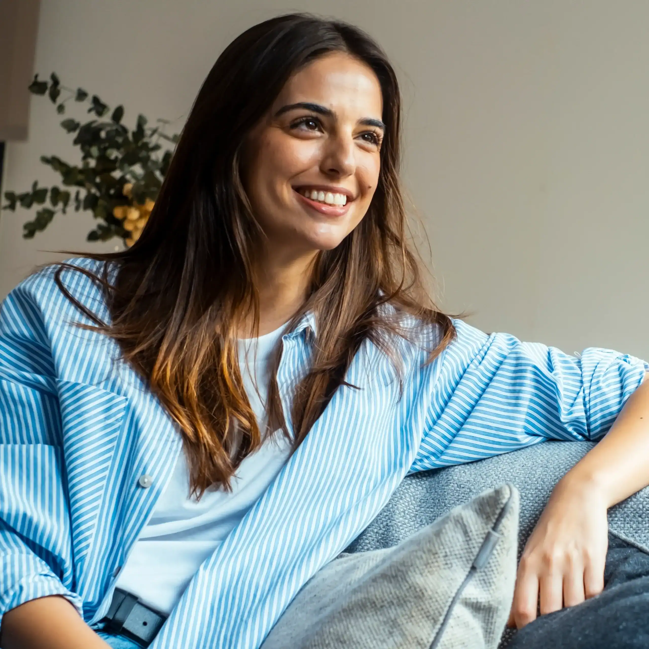 Woman with dark hair and blue striped shirt and smooth skin