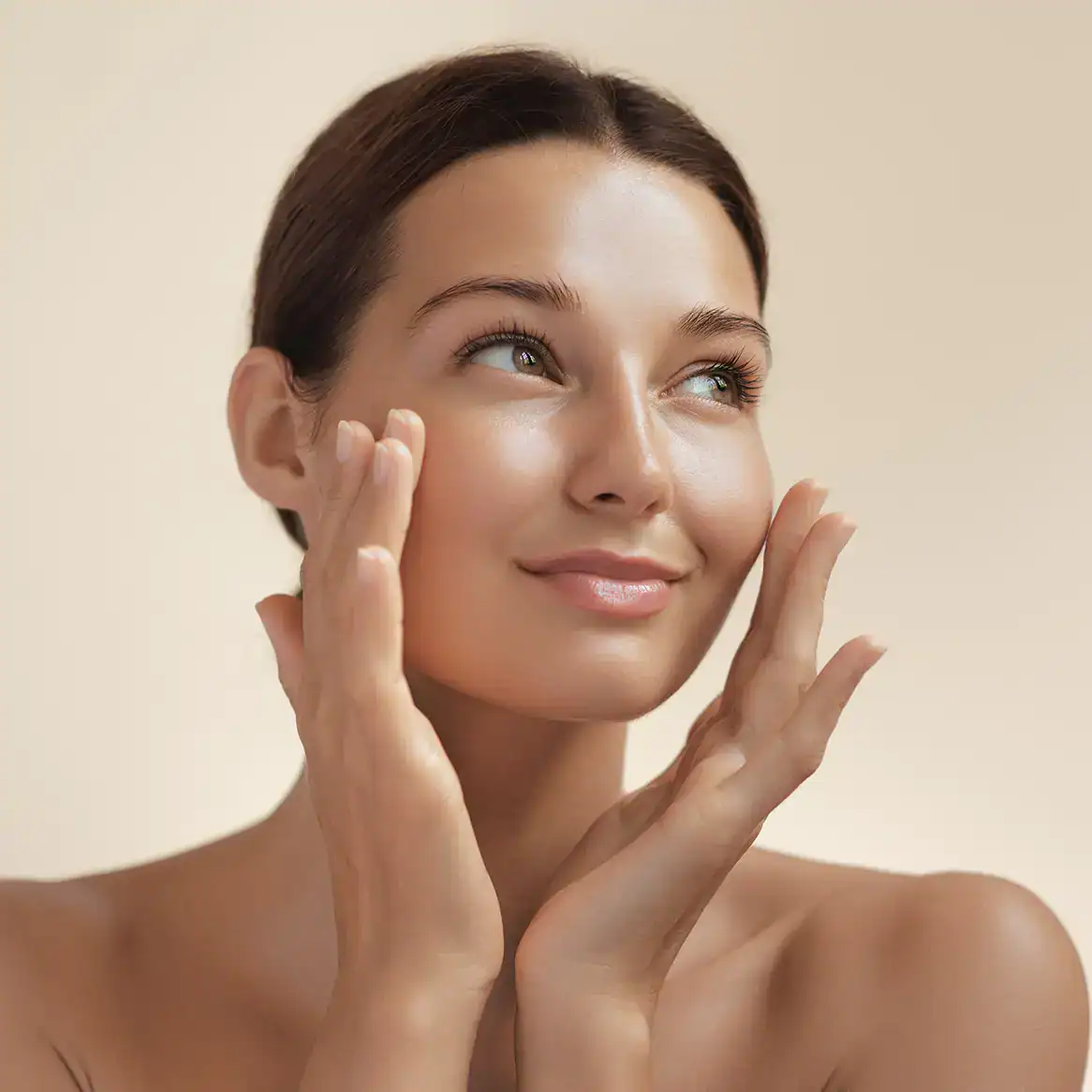 Young woman with flawless skin holds her face in her hands